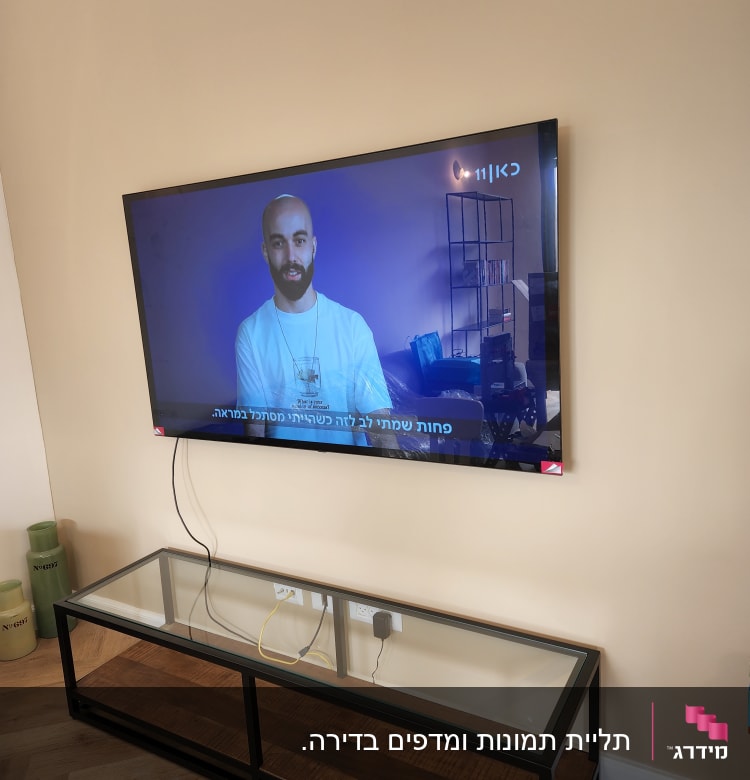 טלוויזיה תלויה על קיר עם כבלים חשמליים